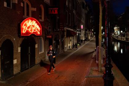 Un hombre camina por el Barrio Rojo casi desierto de Ámsterdam el 25 de marzo de 2021