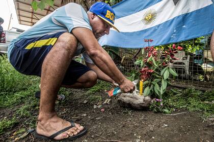 Un hombre coloca flores en la puerta de la casa donde nació Maradona en Azamor 523, Villa Fiorito