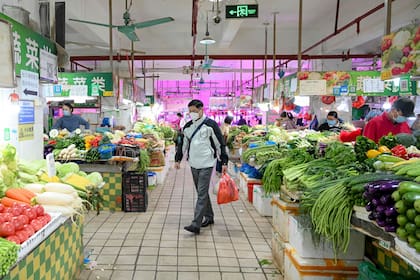 Un hombre compra alimentos en un mercado del distrito de Haizhu, en la ciudad de Guangzhou, en la provincia sureña china de Guangdong, el 1 de diciembre de 2022, tras la relajación de las restricciones de Covid-19 en la ciudad.