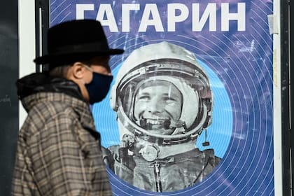 Un hombre, con un barbijo por la pandemia por el Covid-19, pasa junto a una afiche con una imagen del cosmonauta soviético Yuri Gagarin. Hace sesenta años, el cosmonauta soviético Yuri Gagarin se convirtió en la primera persona en el espacio , marcando un nuevo capítulo en la historia de la exploración espacial