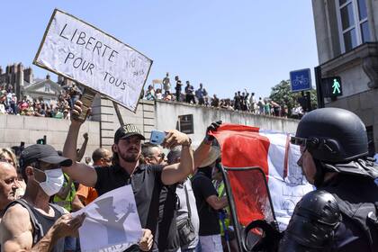 Un hombre con una pancarta que dice "Libertad para todos. No a los pases", durante la marcha de este sábado en Francia