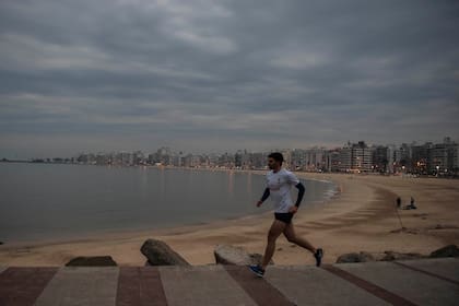 Un hombre corre en la playa de Pocitos en Montevideo, Uruguay. (AP Foto/Matilde Campodonico)