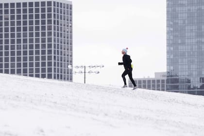 Un hombre corre sobre la nieve en Cricket Hill en Chicago.