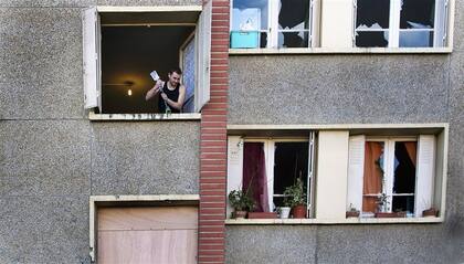 Un hombre despejando ayer su ventana de escombros en el edificio donde vivía Mohamed Merha, en Toulouse
