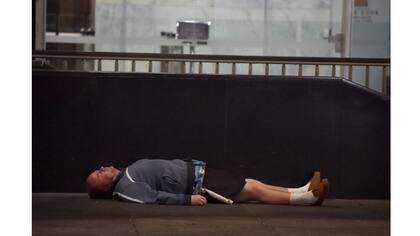 Un hombre duerme en la vereda en el distrito de negocios de Sidney