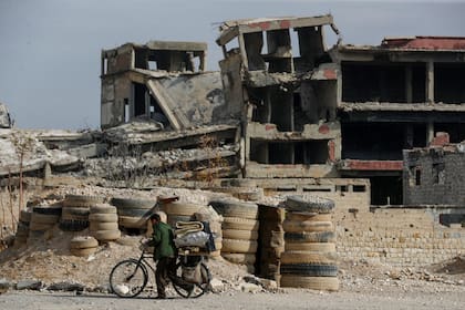 Un hombre empuja su bicicleta por una calle de Harasta, al este de Damasco, Siria, el jueves 12 de diciembre de 2024.