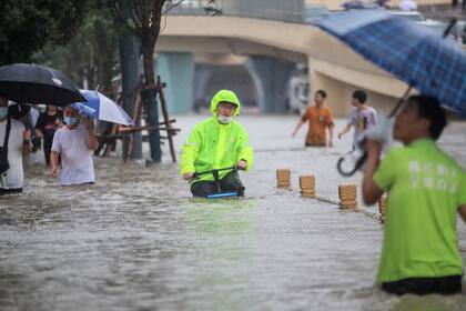 Un hombre en bicicleta en una calle inundada en Zhengzhou, en la provincia central china de Henan