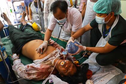 Un hombre, herido tras recibir disparos, recibe tratamiento en un centro médico improvisado en Mandalay el 28 de febrero de 2021, mientras las fuerzas de seguridad continúan reprimiendo las manifestaciones contra el golpe militar