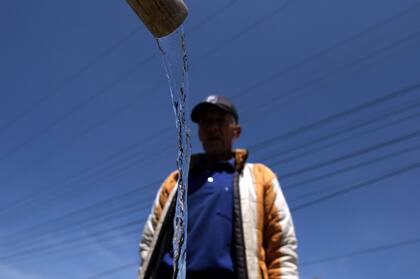 Un hombre junta agua potable de un camión cisterna en La Calera, cerca de Bogotá, el 10 de abril de 2024. 
