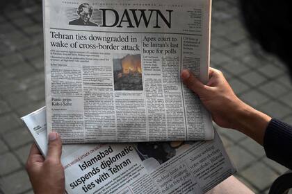Un hombre lee la portada del periódico pakistaní en inglés Dawn que muestra noticias sobre el ataque aéreo de Irán, en Islamabad, el 18 de enero de 2024. 