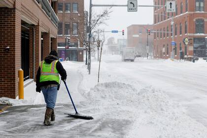 Un hombre limpia la nieve de una calle en Des Moines, Iowa.