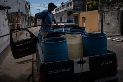 Un hombre llena bidones con agua debido a la escasez causada por las altas temperaturas y la sequía en Veracruz, México, en junio de 2024
