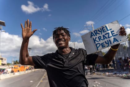 Un hombre lleva un cartel que dice "Ariel rompió el país" durante una protesta contra el primer ministro haitiano, Ariel Henry, pidiendo su renuncia, en Puerto Príncipe, Haití, el 10 de octubre de 2022
