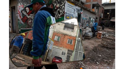 Un hombre lleva un espejo en la Villa 31 en Buenos Aires, Argentina