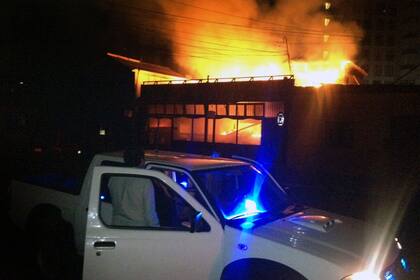 Un hombre mira el restaurant costero que se incendió a raíz del terremoto en la costa de Chile