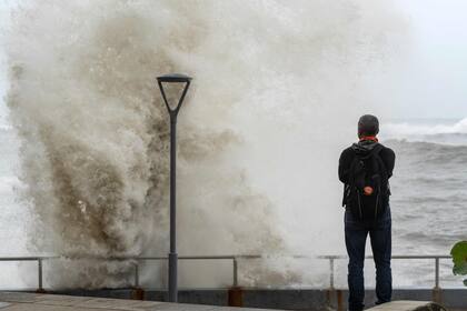 Un hombre mira las olas en el malecón durante la marea alta después del huracán Beryl en Santo Domingo el 2 de julio de 2024