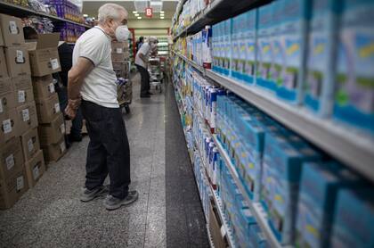 Un hombre mira los precios de la leche en un supermercado en  Caracas ( AP Photo/Ariana Cubillos)