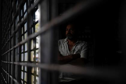 Un hombre mira por la ventana dentro de un restaurante durante un apagón en Caracas.