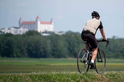 Un hombre monta su bicicleta hacia el cruce fronterizo de Bratislava-Berg entre Austria y Eslovaquia durante la pandemia de coronavirus