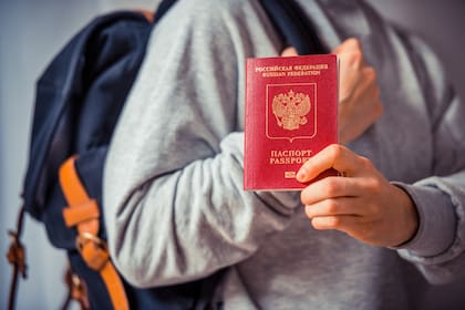 Un hombre muestra su pasaporte ruso