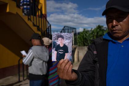 Un hombre muestra un retrato de Wilmer Tulul, en Tzucubal, Guatemala, el miércoles 29 de junio de 2022. Wilmer y su primo Pascual, ambos de 13 años, estaban entre los decenas de fallecidos dentro de un camión con remolque cerca de los patios de depósitos de chatarras en las afueras de San Antonio, Texas, el lunes, en lo que se cree que es el episodio de contrabando humano más mortífero en la historia de Estados Unidos.