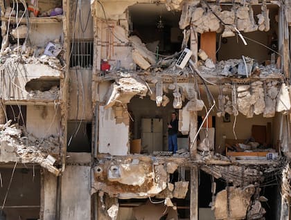 Un hombre observa a los rescatistas mientras revisan entre los escombros en busca de personas desaparecidas tras el ataque israelí del viernes sobre los suburbios del sur de Beirut, el lunes 23 de septiembre de 2024