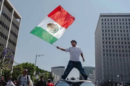 Un hombre ondea la bandera mexicana en las protestas en Los Ángeles