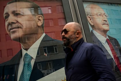 Un hombre pasa junto a carteles electorales del presidente de Turquía y candidato a la reelección de la Alianza Popular, Recep Tayyip Erdogan, a la izquierda, y el líder del partido CHP y candidato de la Alianza Nacional, Kemal Kilicdaroglu, en Estambul, el viernes 5 de mayo de 2023 en Estambul, Turquía. (AP Foto/Emrah Gurel)