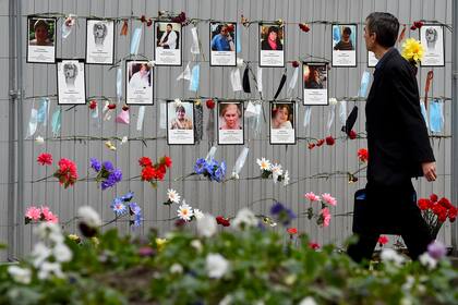 Un hombre pasa junto a un monumento improvisado para trabajadores médicos que murieron a causa del nuevo coronavirus establecido fuera del departamento de salud local en San Petersburgo el 11 de mayo de 2020