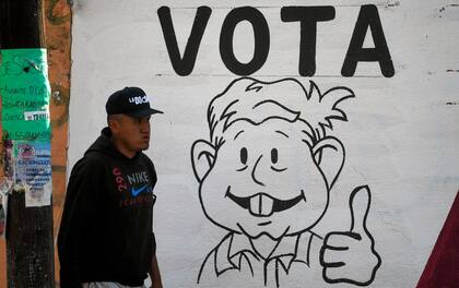 Un hombre pasa junto a un muro con un grafiti que promueve la consulta popular sobre la revocación del mandato del presidente mexicano Andrés Manuel López Obrador en Chimalhuacán, México, el 10 de abril de 2022. 