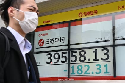 Un hombre pasa junto a un tablero electrónico que muestra el precio de las acciones del índice Nikkei de la Bolsa de Tokio en Tokio el 19 de marzo de 2024.