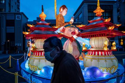 Un hombre pasa junto a una decoración festiva el primer día del Año Nuevo Lunar del Buey en el área de Chinatown de Yokohama