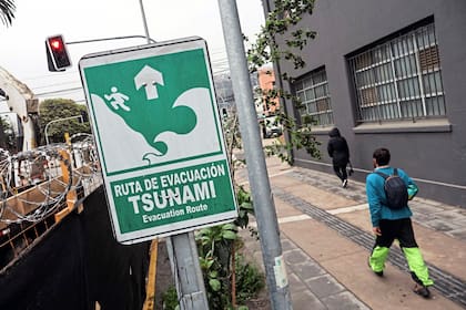 Un hombre pasa junto a una señal de ruta de evacuación por tsunami durante una alerta de tsunami en Valparaíso, Chile, el 30 de julio de 2025