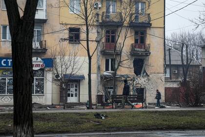 Un hombre pasa por delante de un edificio de apartamentos alcanzado por un bombardeo en Mariupol, Ucrania, el miércoles 2 de marzo de 2022.
