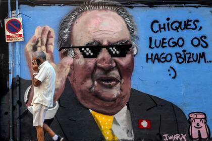 Un hombre pasa por un grafiti del artista valenciano J. Warx que hace referencia al escándalo de corrupción que envuelve al ex rey Juan Carlos de España en una calle de Valencia, el 8 de agosto 2020