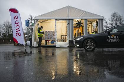 Un hombre prepara kits de prueba de PCR para ser recolectados por los conductores de Taxi Stockholm en una estación para entregarlos a las personas que sospechan que tienen Covid-19, el 4 de diciembre de 2020 en un suburbio de Estocolmo, Suecia