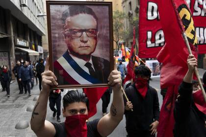Un hombre que sostiene una fotografía del difunto presidente de Chile, Salvador Allende, participa en una manifestación que conmemora el 50 aniversario de un golpe militar liderado por el general Augusto Pinochet en Santiago, Chile, el domingo 10 de septiembre de 2023. Allende fue asesinado durante el golpe.