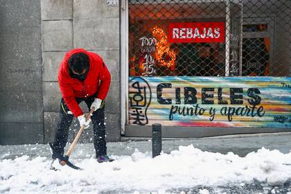 Un hombre quita el hielo de la vereda, en Madrid