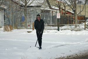 Un hombre quita nieve de un camino en Denver