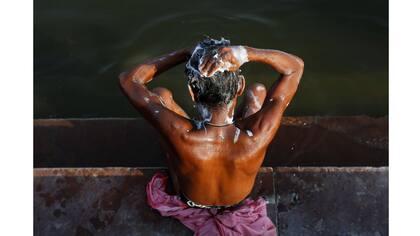 Un hombre se lava a orillas del río Ganges en Varanasi