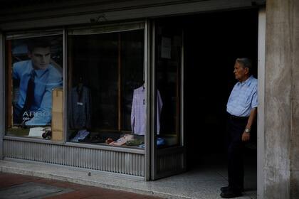 Un hombre se para en la entrada de una tienda durante un apagón en Caracas.