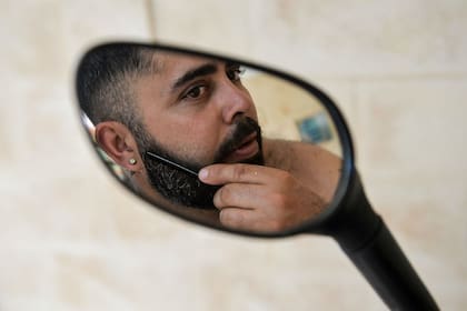 Un hombre se peina la barba frente al espejo de su moto en La Habana, el 16 de julio de 2019