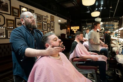 Un hombre se prepara para cortarse el pelo en una barbería en Manchester, Inglaterra