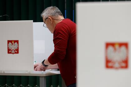 Un hombre se prepara para votar durante las elecciones parlamentarias en Varsovia, Polonia, el domingo 15 de octubre de 2023. (AP Foto/Michal Dyjuk)