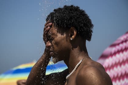 Un hombre se refresca en una ducha en la playa de Ipanema, Río de Janeiro, Brasil.
