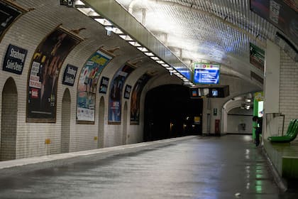 Un hombre se sienta en una plataforma desierta de una estación de metro, el 17 de octubre de 2020 en París, al inicio de un toque de queda nocturno implementado para combatir la propagación del coronavirus