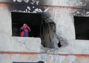 Un hombre se sostiene la cabeza mientras está en su apartamento en una casa de varios pisos que fue destruida tras un ataque ruso en Kharkiv, Ucrania, el jueves 24 de marzo de 2022. 