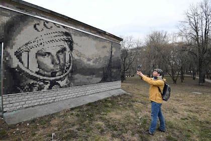 Un hombre toma una fotografía de un mosaico que representa al cosmonauta soviético Yuri Gagarin, en Moscú