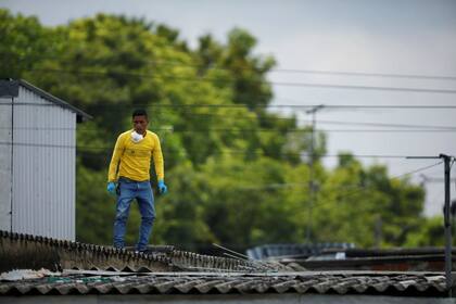 Un hombre trabaja en el sitio donde las autoridades estaban excavando una fosa que contenía muchos cadáveres de mujeres.