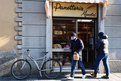 Un hombre usa barbijo a la salida de una panadería en Codogno, Italia